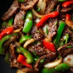 Delicious Chinese pepper steak with onions served in a takeout container.