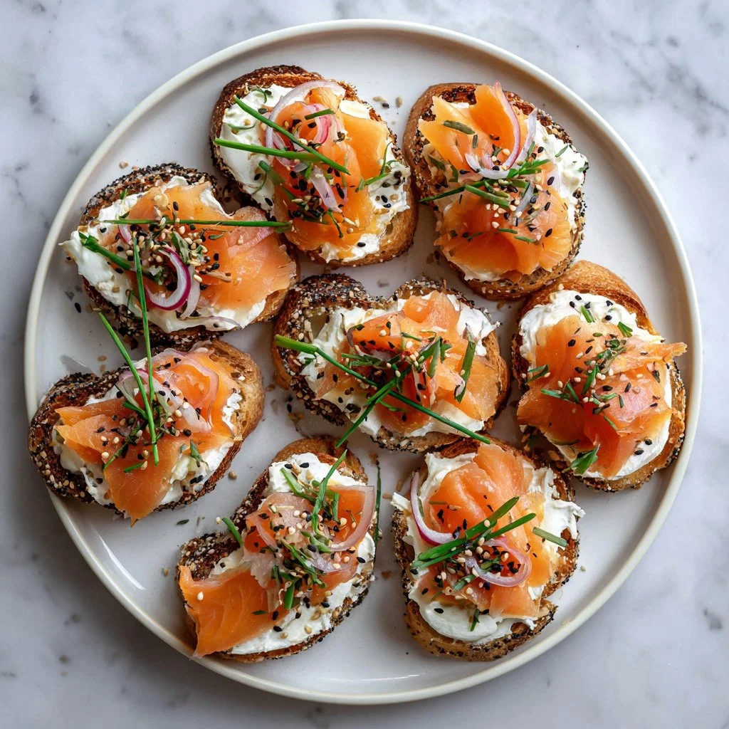 Smoked salmon crostini with creamy chive cheese topping on a serving platter